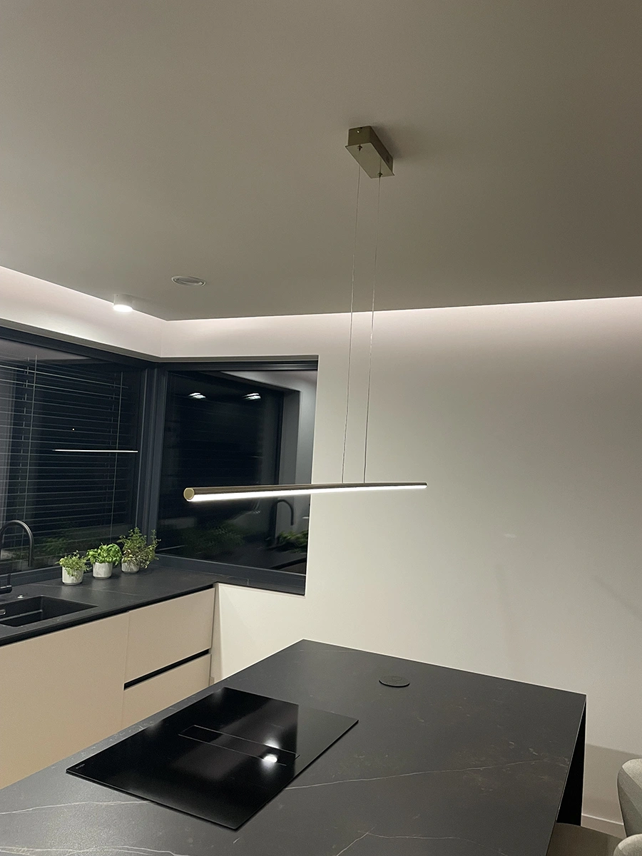 Złota lampa Led Line 150 cm nad wyspą kuchenną w ciemnej aranżacji, barwa neutralna 4000K
