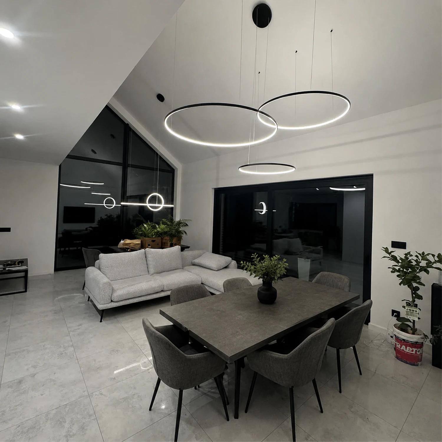 Czarna lampa Led Orbit S No.3 nad stołem w nowoczesnej jadalni z wysokim salonem