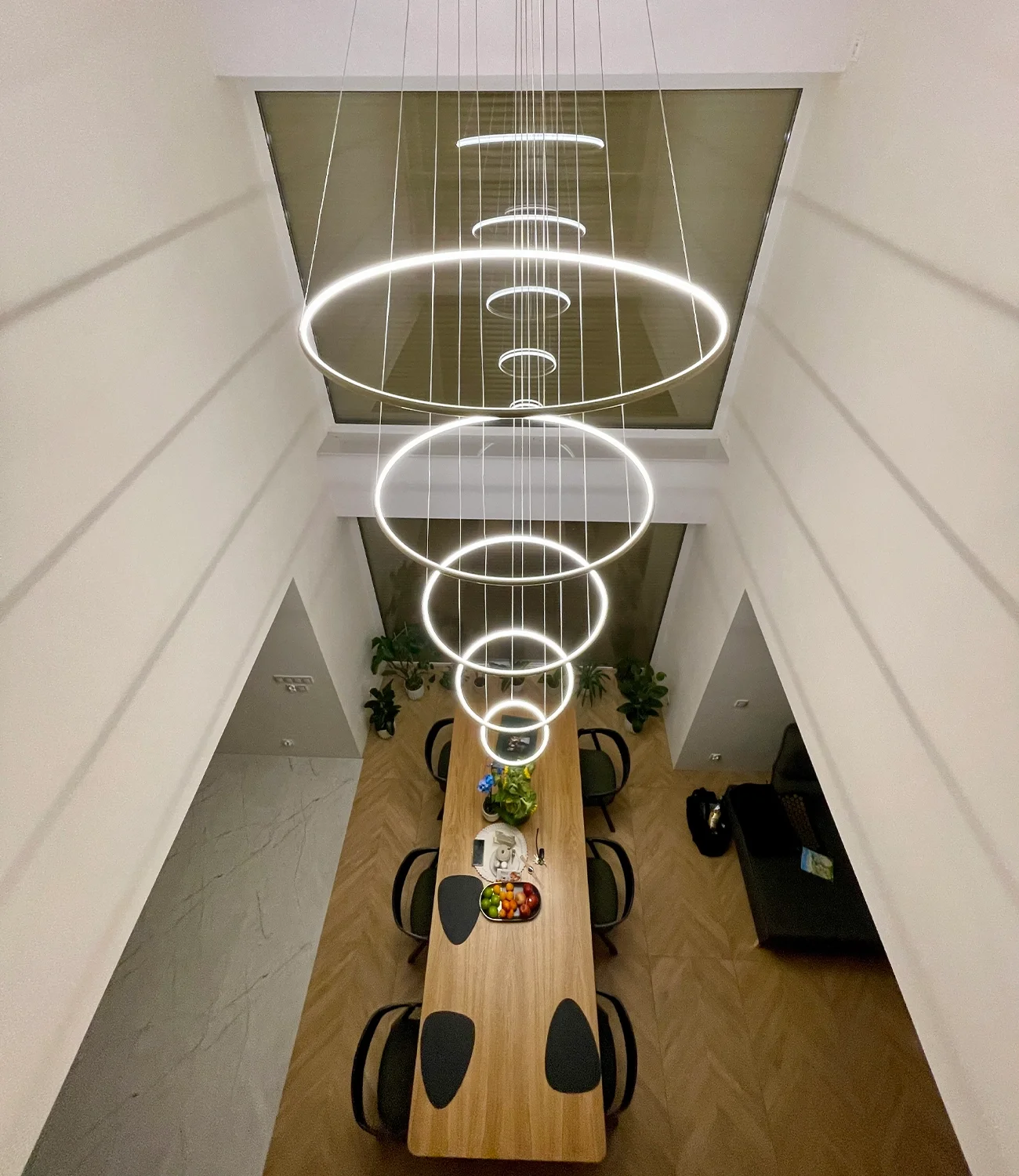 Zobacz żyrandol Led Orbit No.5 w nowoczesnym wnętrzu nad dużym stołem – wersja złota