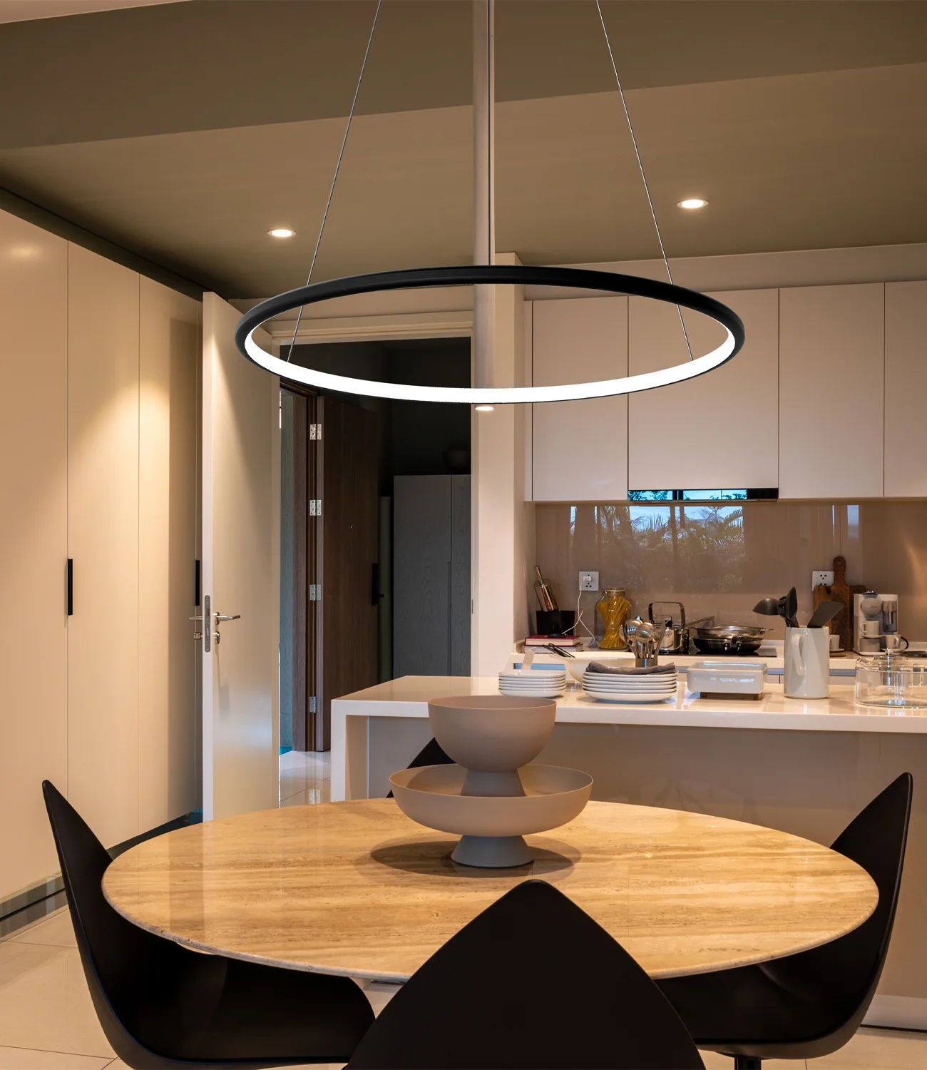 Czarna lampa ring Led Orbit No.1 o średnicy 80 cm zawieszona nad stołem w kuchni