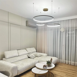Złota lampa wisząca LED Orbit z trzema ringami – kliknij, aby zobaczyć więcej opcji oświetlenia do salonu