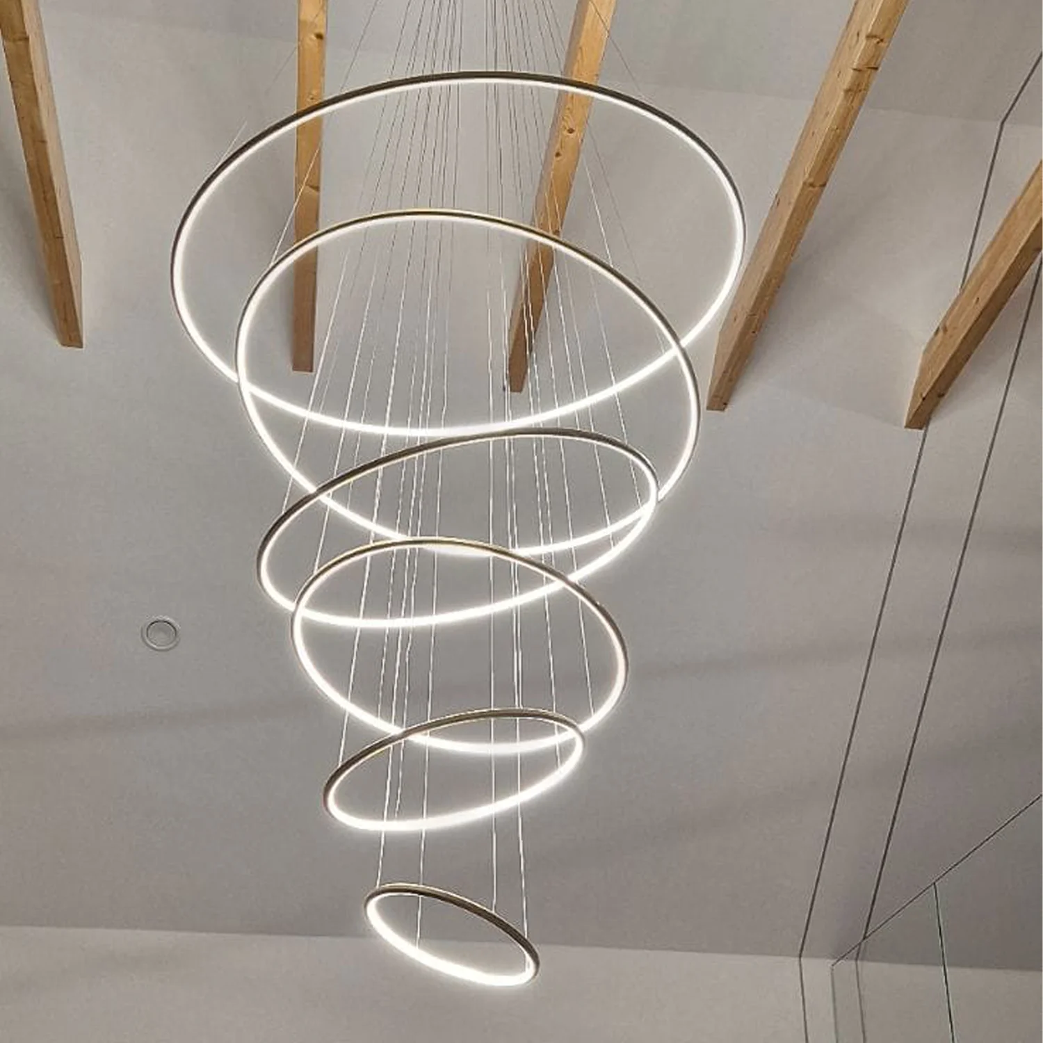 Designerska złota lampa ring LED Orbit No.6 – sześć obręczy LED w eleganckiej jadalni