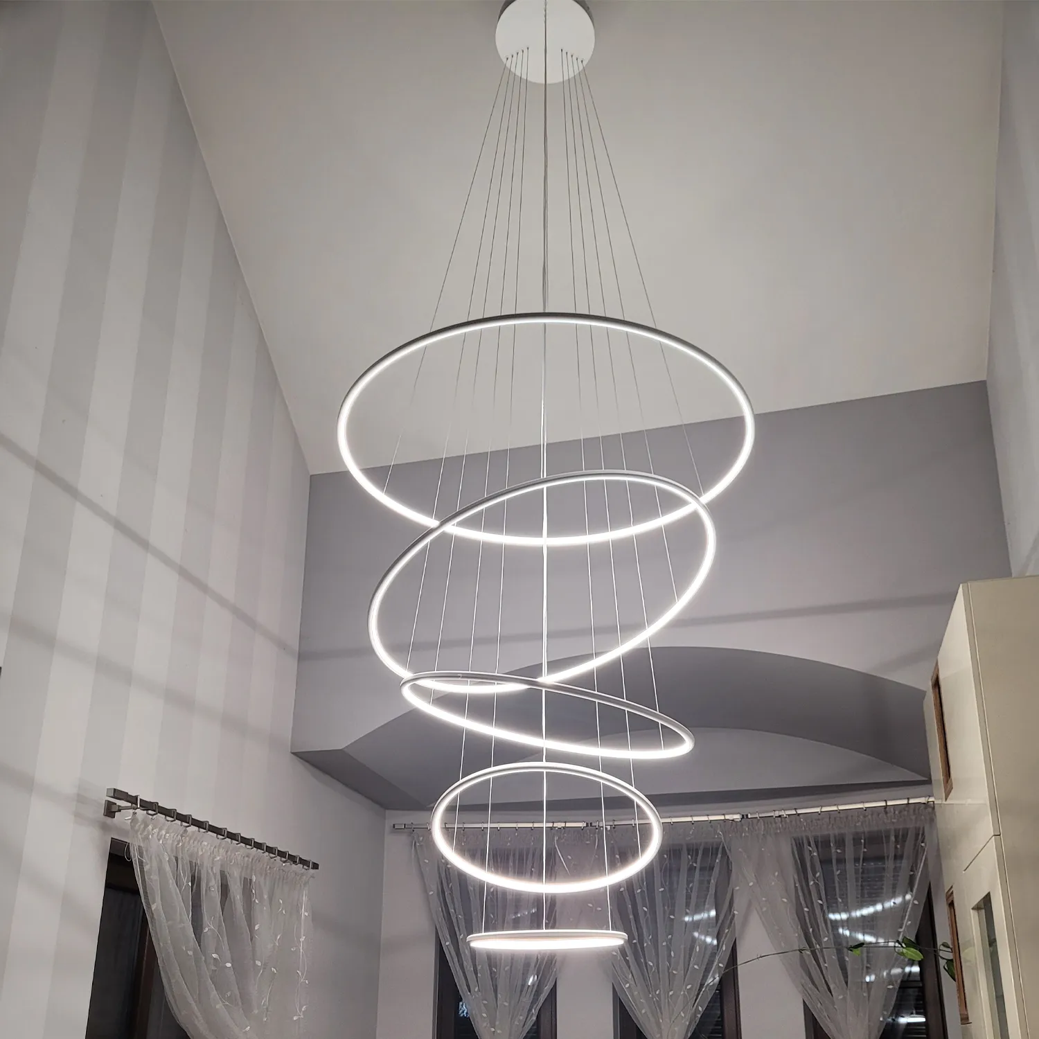 Biała lampa wisząca LED Orbit No.5 120 cm pięć ringów w eleganckim salonie